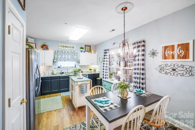 a view of a dining room with furniture a kitchen and chandelier