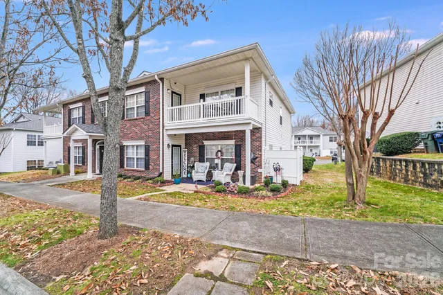 a view of a white house with a yard patio and fire pit