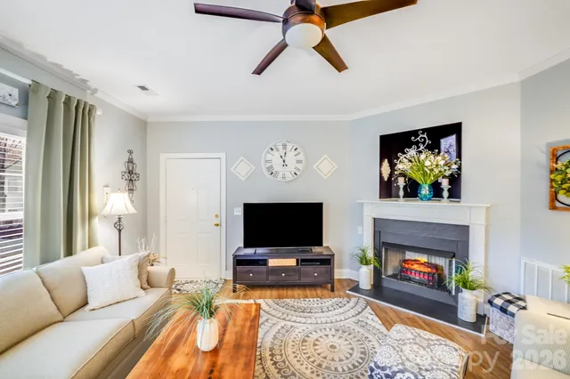 a living room with furniture a flat screen tv and a fireplace