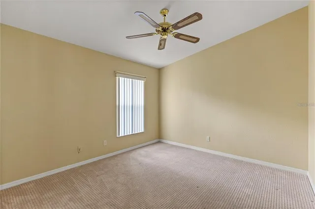 an empty room with a window and a ceiling fan