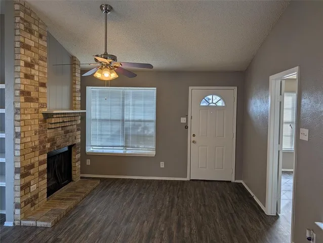 a view of empty room with wooden floor and fireplace