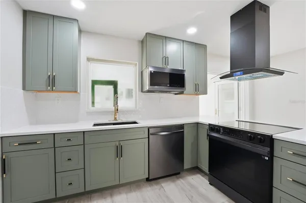 a kitchen with cabinets stainless steel appliances and a sink