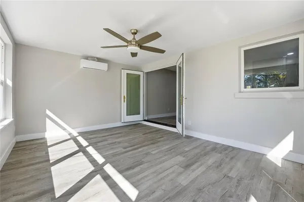 a view of an empty room with wooden floor and a window