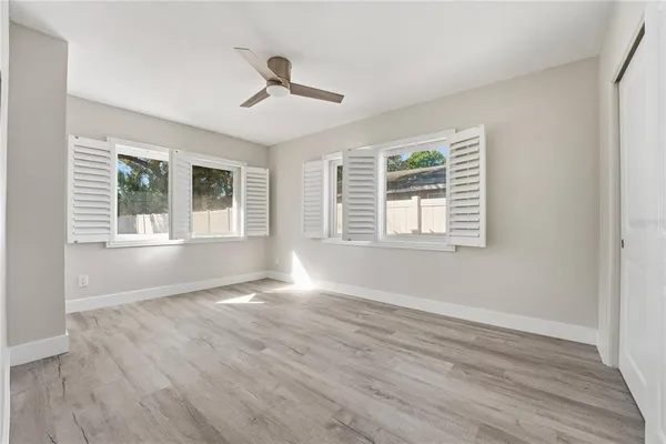 a view of an empty room with a window and wooden floor