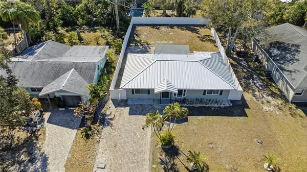 an aerial view of a house with swimming pool and large trees