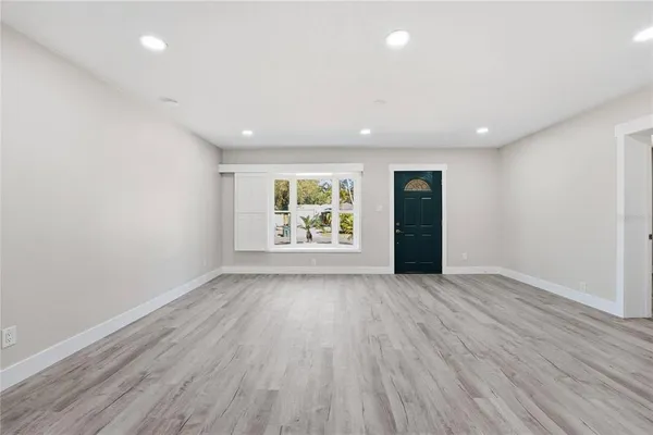 an empty room with window and wooden floor