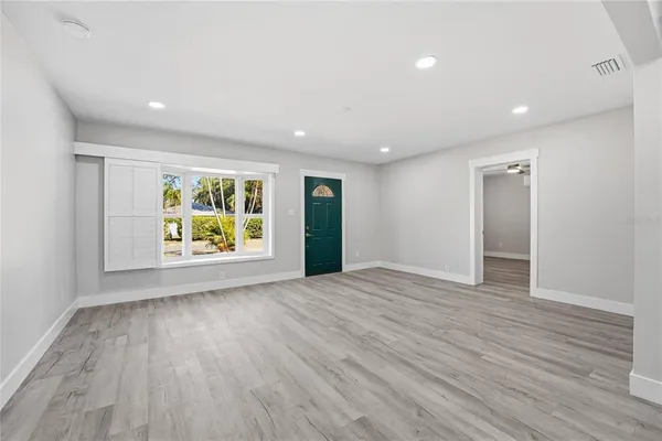 an empty room with window and wooden floor