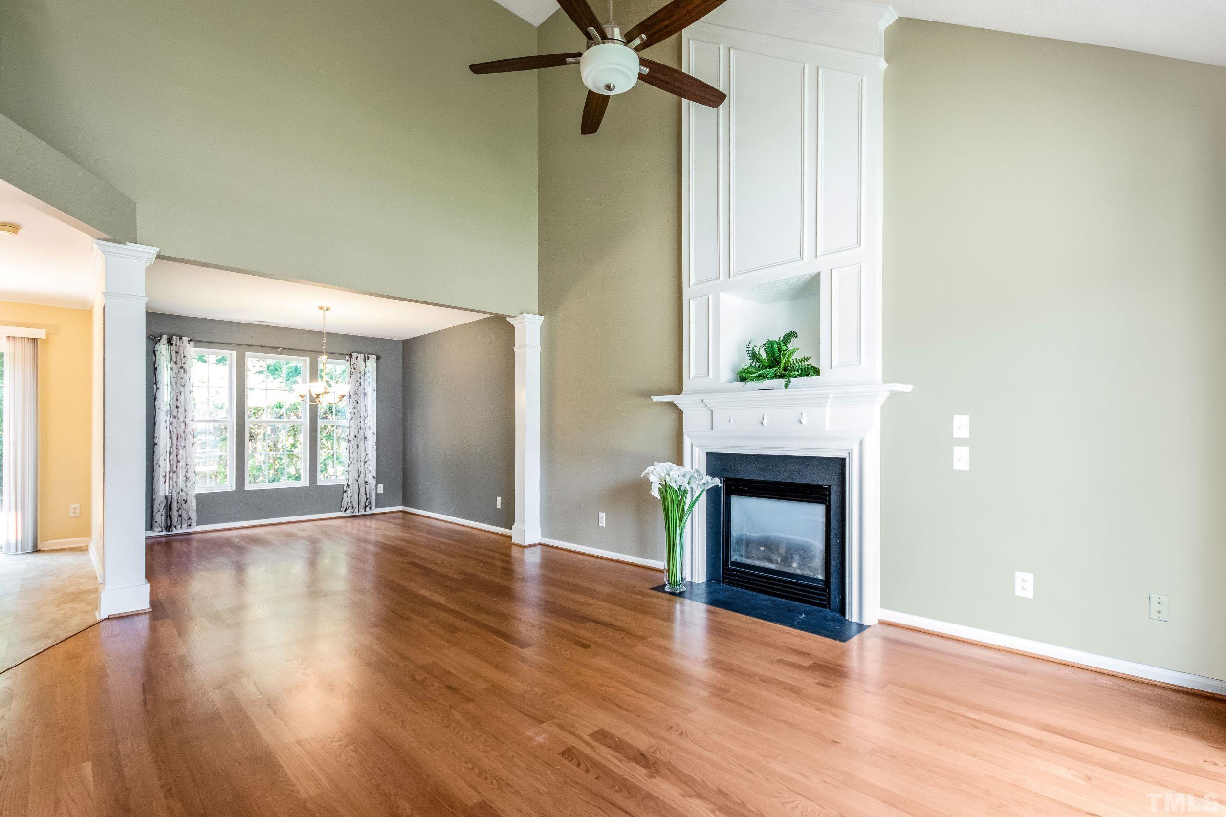 4827 Shallowbrook Trail Raleigh, NC 27616 - Photo 2 of 30 an empty room with wooden floor a fireplace and windows
