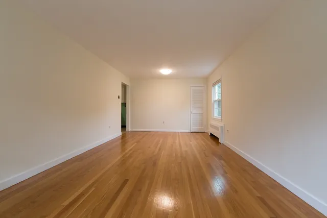 a view of an empty room and wooden floor