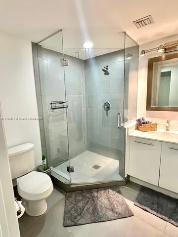 a bathroom with a granite countertop sink a toilet and shower