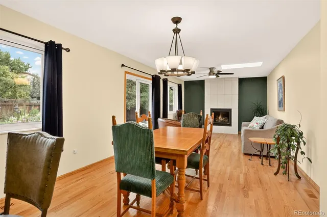 a dining room with furniture a chandelier and wooden floor