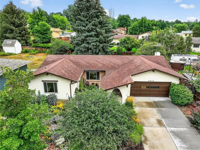 an aerial view of a house with yard and green space