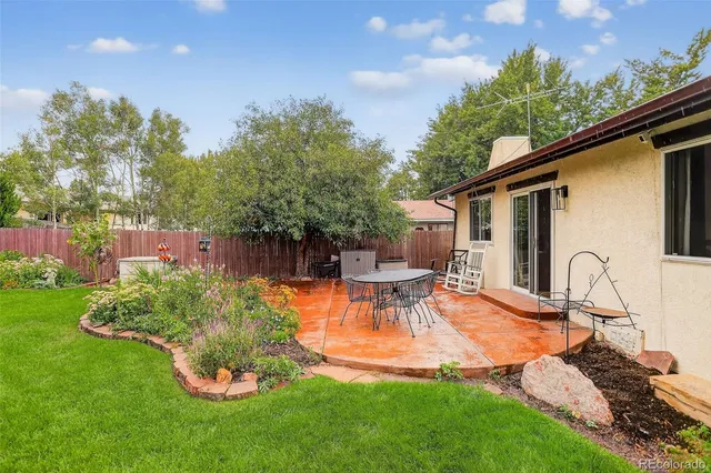 a view of a backyard with table and chairs potted plants and a palm tree