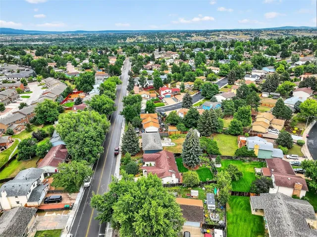 an aerial view of residential houses with outdoor space and trees