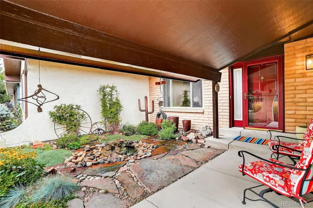 a living room with patio furniture and a potted plant