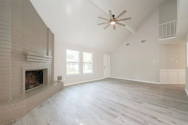 wooden floor fireplace and windows in an empty room