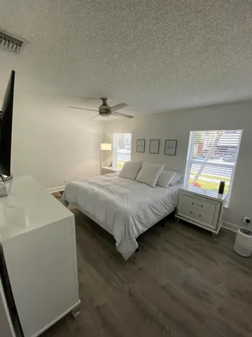 a bedroom with a bed and a tv on dresser