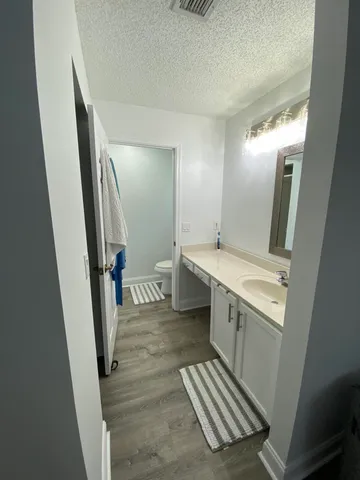 a spacious bathroom with a sink a mirror and a toilet
