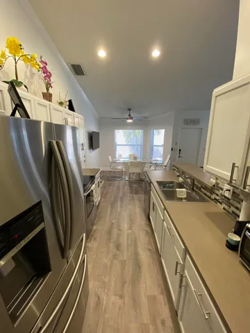 a view of a kitchen with a sink and wooden floor