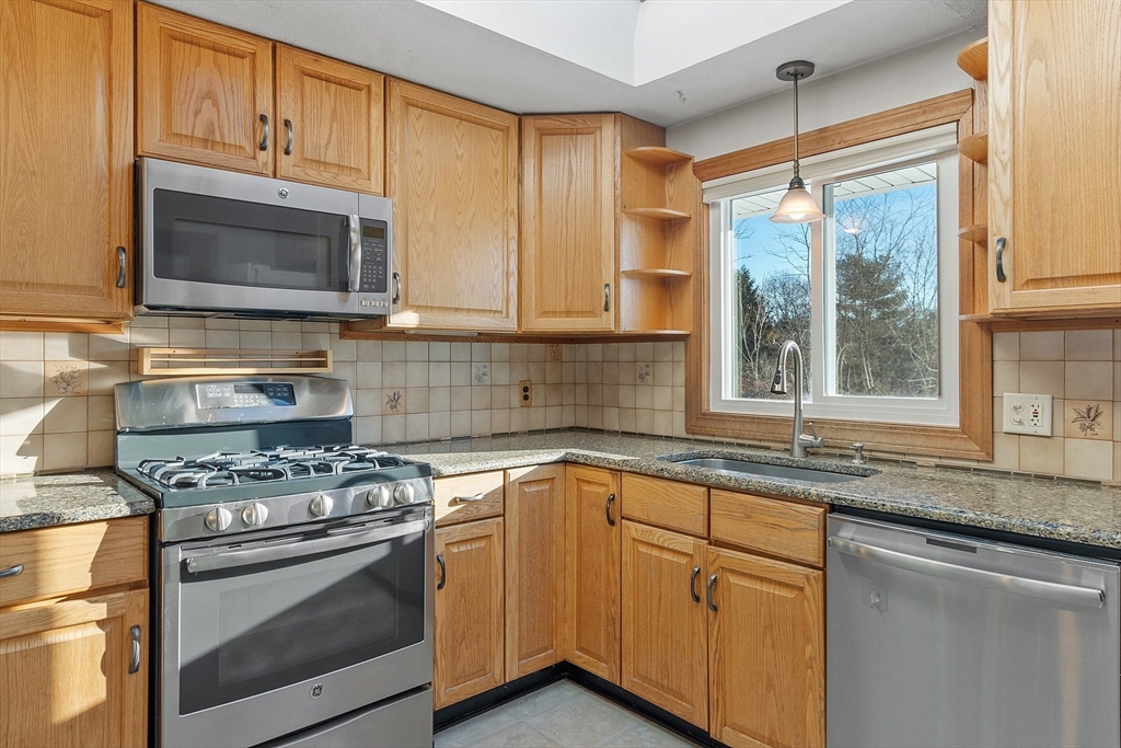 187 Mill Road Chelmsford, MA 01824 - Photo 3 of 32 a kitchen with granite countertop cabinets stainless steel appliances a sink and a window