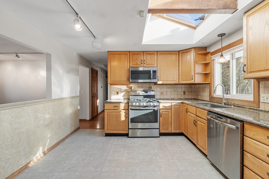 187 Mill Road Chelmsford, MA 01824 - Photo 5 of 32 a kitchen with stainless steel appliances granite countertop a stove a sink and a refrigerator