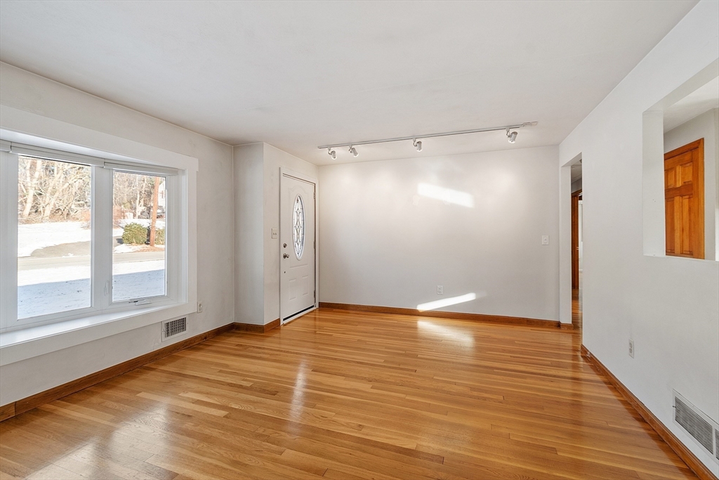 187 Mill Road Chelmsford, MA 01824 - Photo 7 of 32 a view of an empty room with wooden floor and a window
