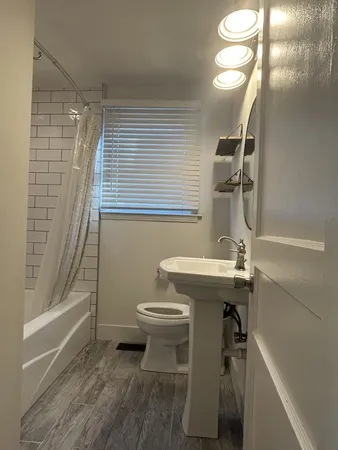 a bathroom with a sink a toilet and shower