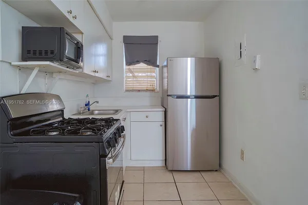 a kitchen with a refrigerator and a stove top oven
