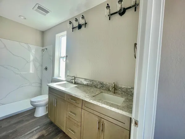 a bathroom with a granite countertop sink toilet and shower