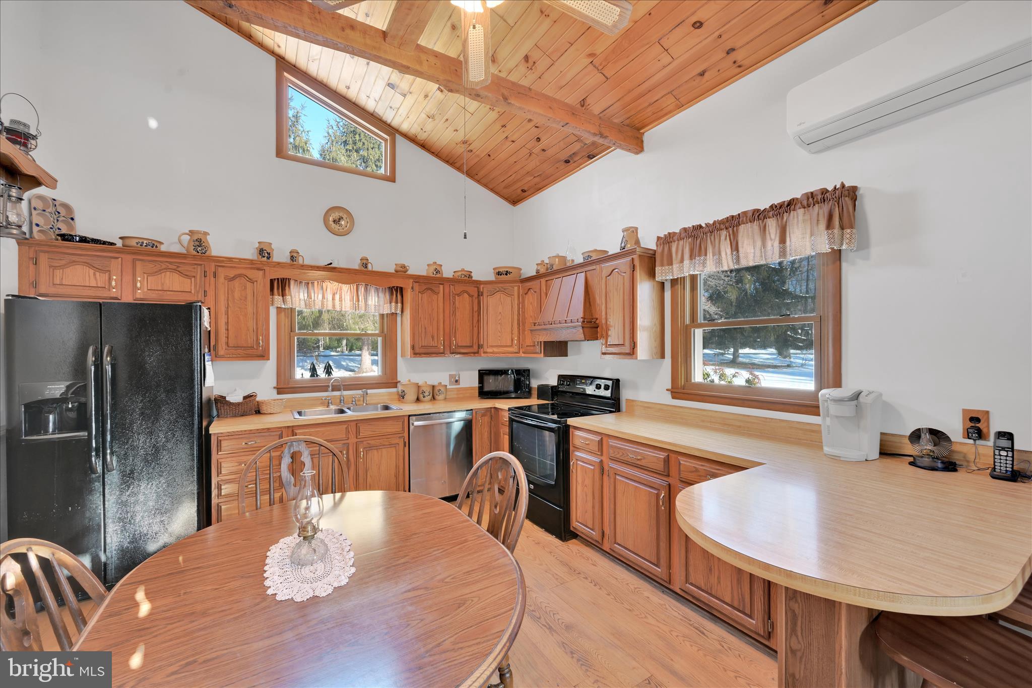 166 Camp Strauss Road Fredericksburg, PA 17026 - Photo 15 of 40 a kitchen with stainless steel appliances granite countertop a stove a refrigerator a kitchen island a dining table and chairs with wooden floor