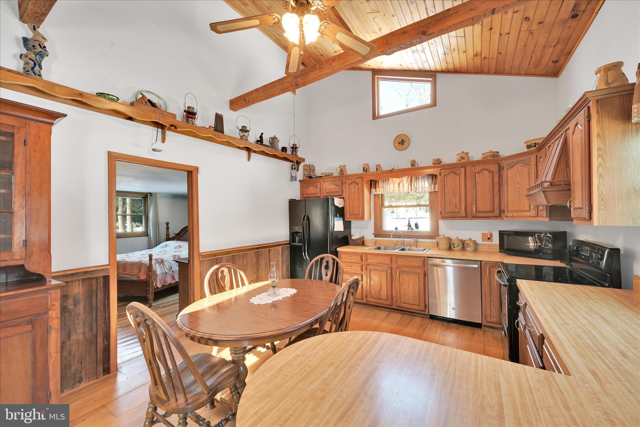 166 Camp Strauss Road Fredericksburg, PA 17026 - Photo 18 of 40 a kitchen with stainless steel appliances granite countertop a stove a sink dishwasher a dining table and chairs with wooden floor