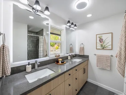 a bathroom with a granite countertop sink a large mirror and a shower