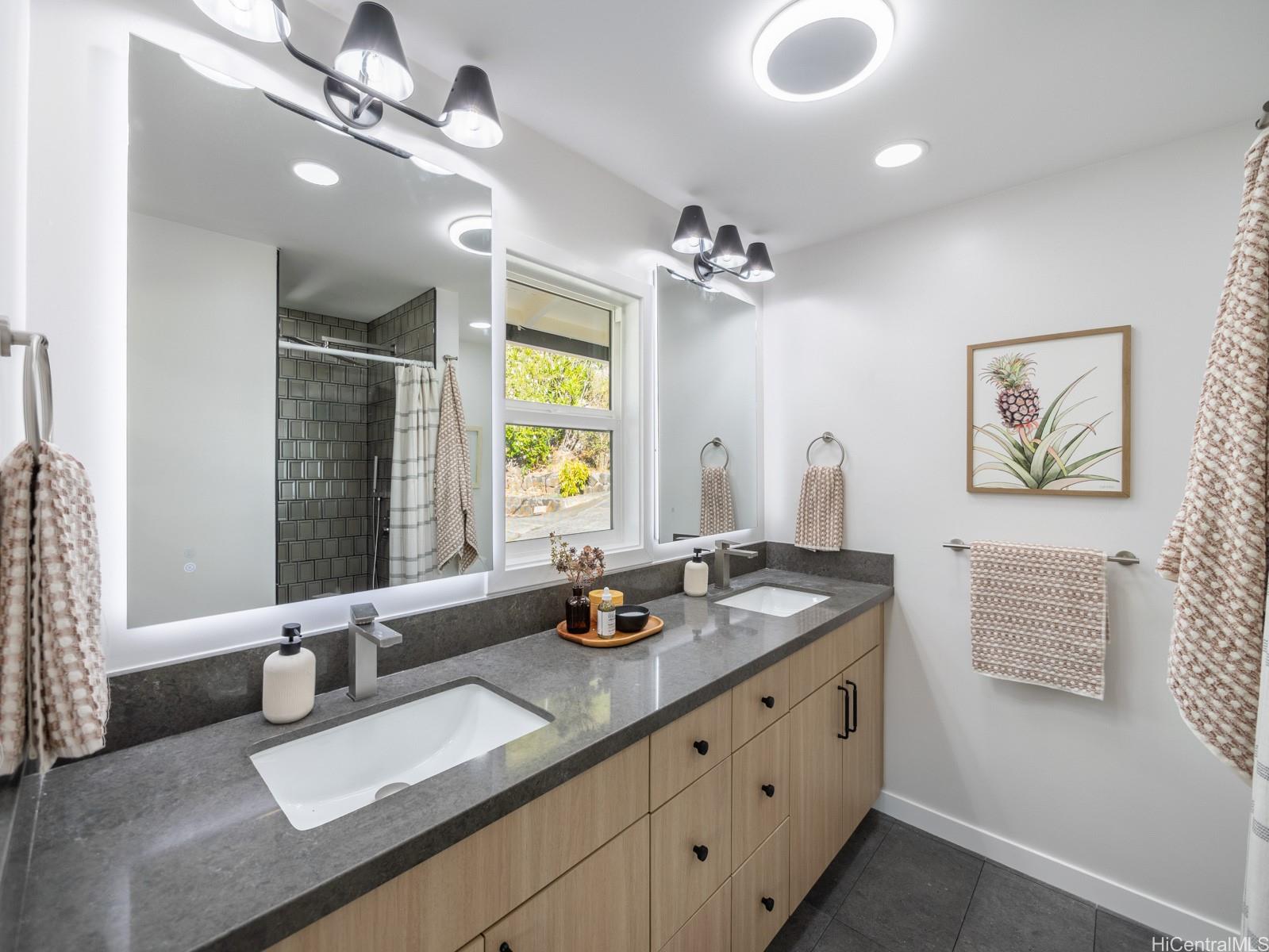 1843 A 10th Avenue Honolulu, HI 96816 - Photo 12 of 22 a bathroom with a granite countertop sink a large mirror and a shower