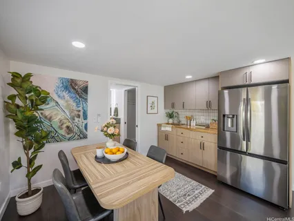 a kitchen with stainless steel appliances granite countertop a refrigerator a sink a stove a dining table and chairs