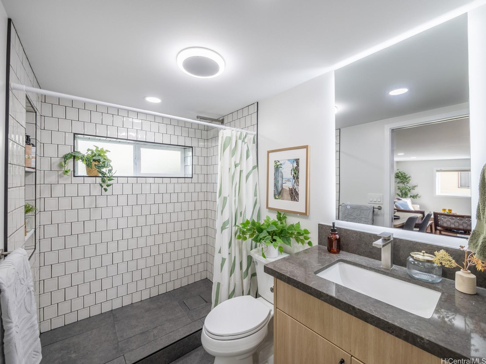 1843 A 10th Avenue Honolulu, HI 96816 - Photo 21 of 22 a bathroom with a granite countertop toilet a sink a mirror and shower