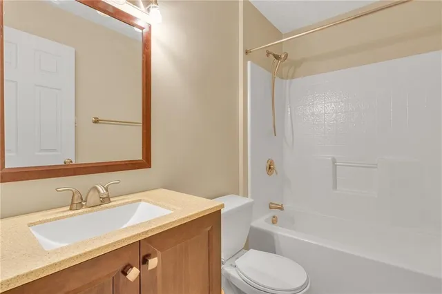 a bathroom with a sink toilet vanity and shower