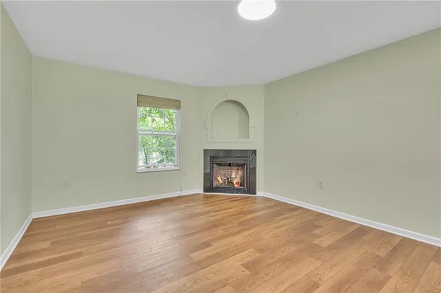 a view of an empty room with a window and fireplace