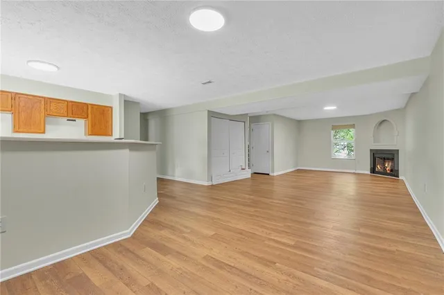 a view of empty room with wooden floor and fireplace