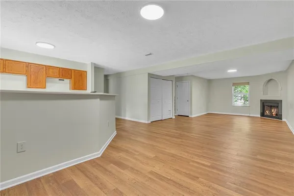a view of empty room with wooden floor and fireplace
