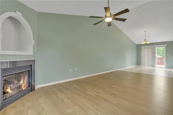a view of an empty room with window and fireplace