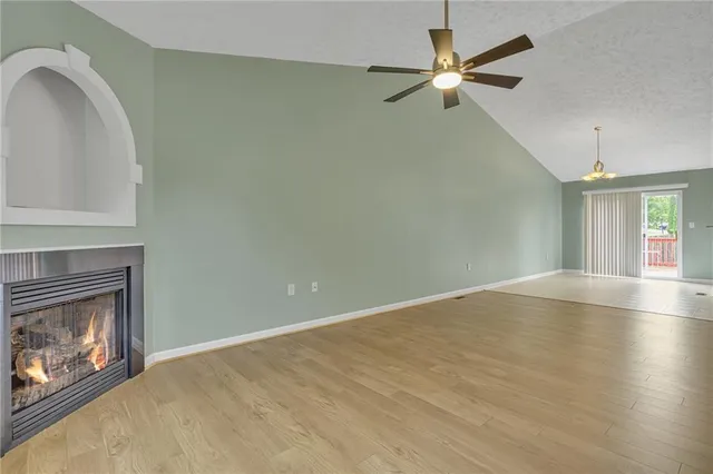 a view of an empty room with window and fireplace