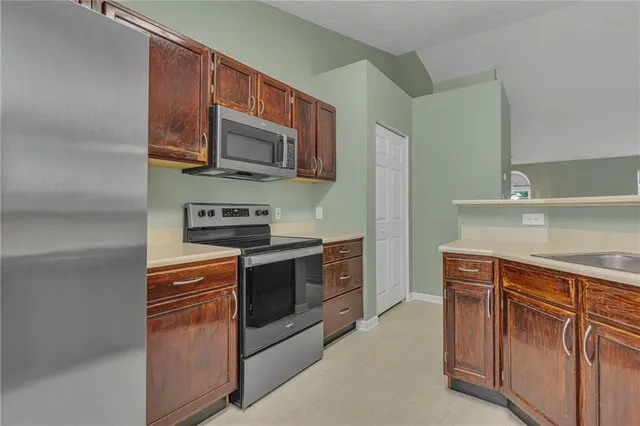 a kitchen with stainless steel appliances granite countertop a stove microwave and sink