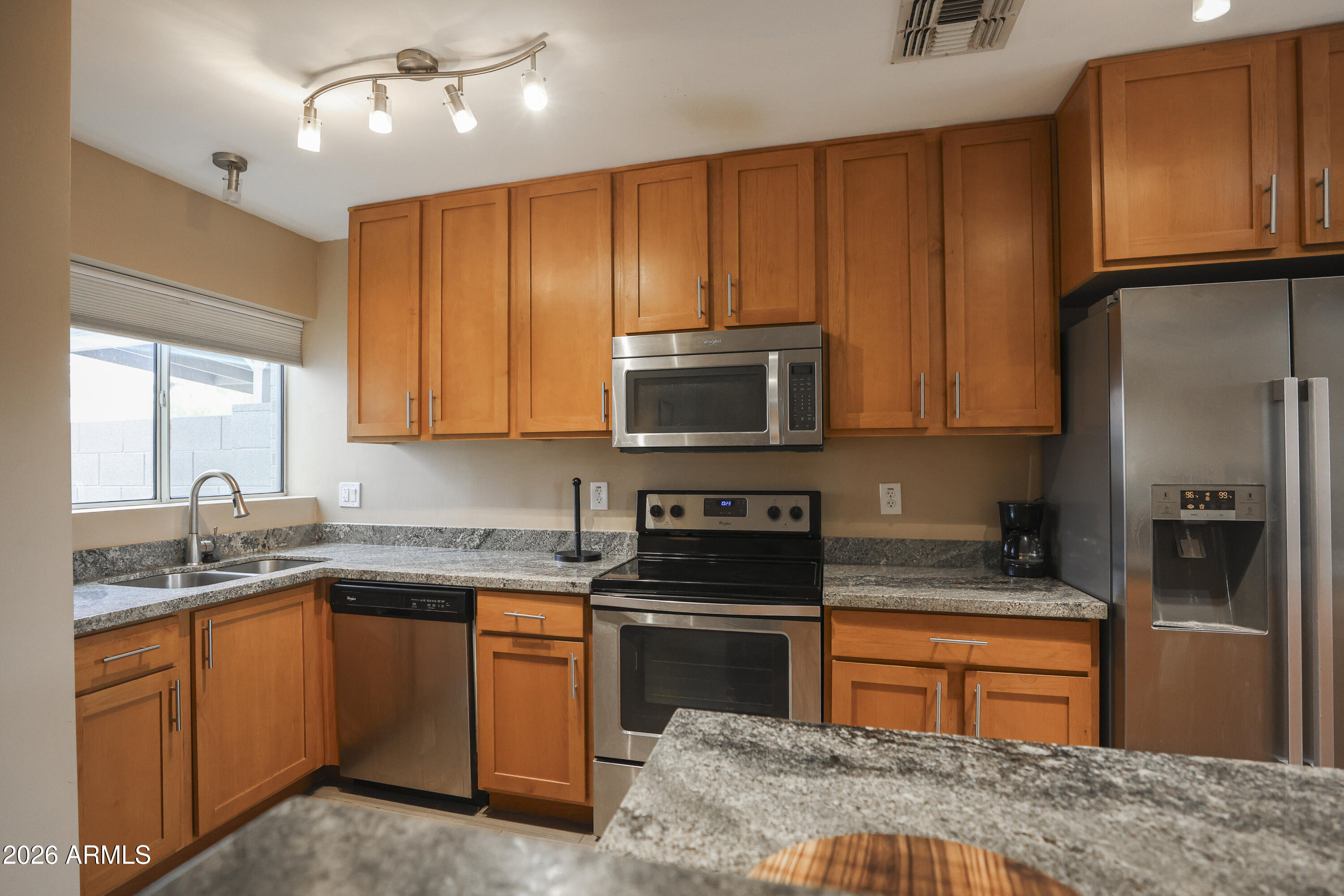 925 West McDowell Road, Unit 108 Phoenix, AZ 85007 - Photo 3 of 22 a kitchen with stainless steel appliances granite countertop wooden cabinets a stove top oven a sink and dishwasher