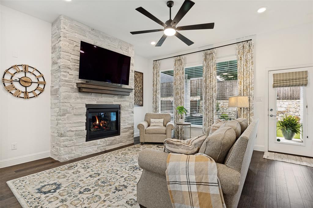 229 Savannah Lane Oak Point, TX 75068 - Photo 10 of 26 a living room with furniture a flat screen tv and a fireplace