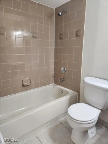 a white toilet and tub sitting next to a bathroom sink