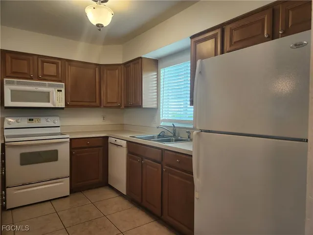 a kitchen with a refrigerator sink and cabinets
