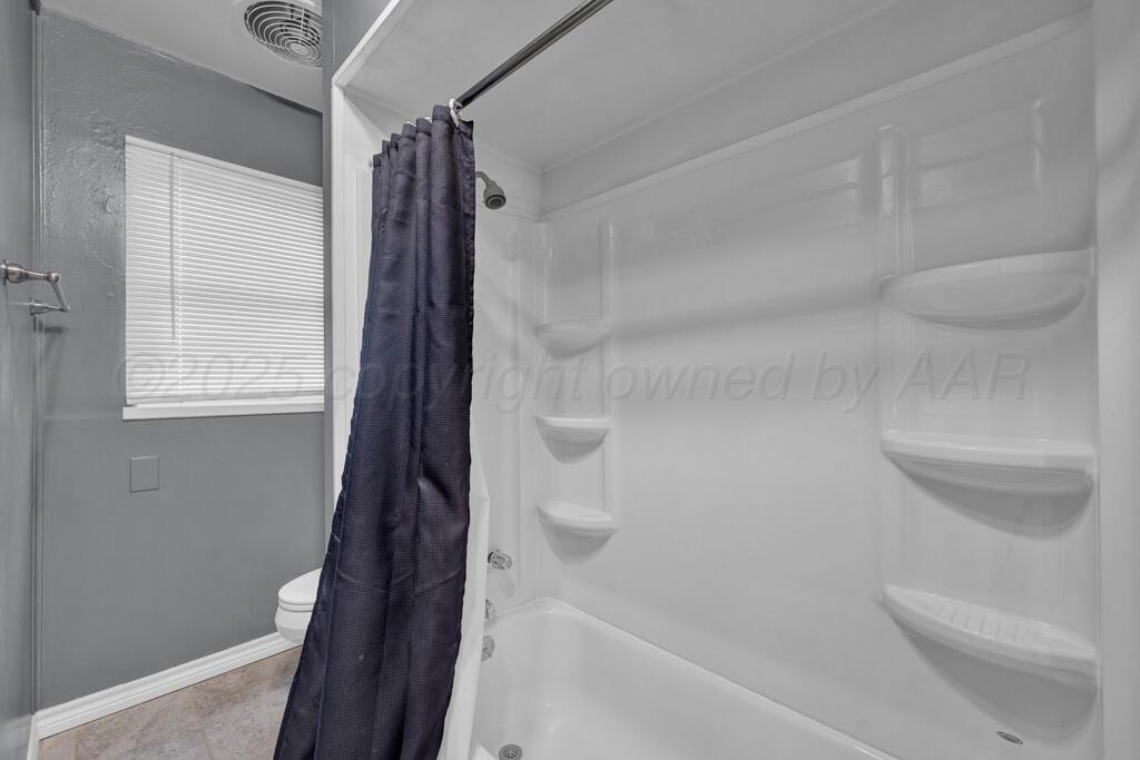 2909 South Marrs Street Amarillo, TX 79103 - Photo 13 of 21 a bathroom with a shower and a toilet