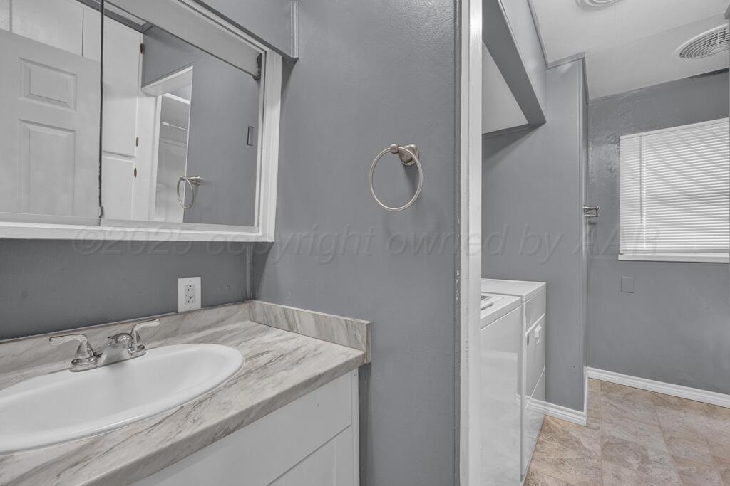 2909 South Marrs Street Amarillo, TX 79103 - Photo 14 of 21 a bathroom with a sink and mirror