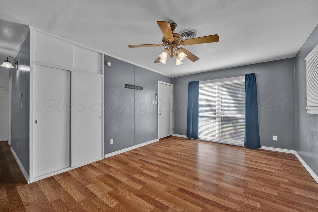 2909 South Marrs Street Amarillo, TX 79103 - Photo 4 of 21 a view of an empty room with a window and wooden floor