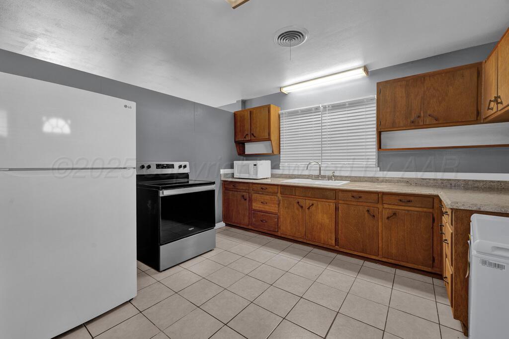 2909 South Marrs Street Amarillo, TX 79103 - Photo 6 of 21 a kitchen with stainless steel appliances granite countertop a stove a sink and a refrigerator